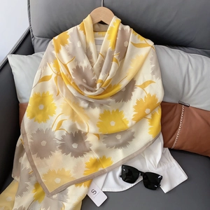 Close-up of lightweight cotton linen scarf featuring yellow sunflower prints on a hanger