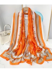 Close-up of orange navy-style satin scarf featuring anchor and chain patterns with high luster