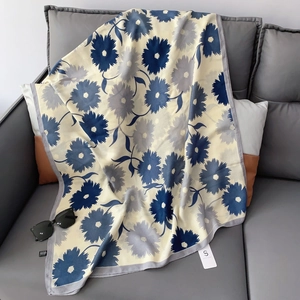 Detailed close-up of soft cotton linen floral scarf with blue daisies on yellow base