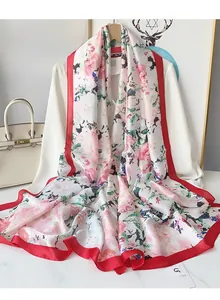 Detailed texture of white floral silk scarf with red satin edges on white blazer