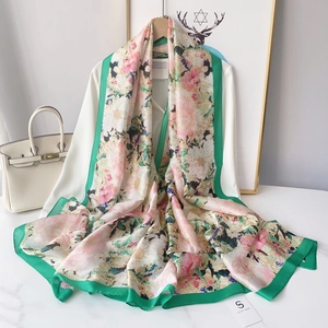 Close-up of silk scarf with floral print and elegant green border for women