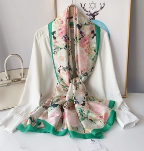 Detailed texture of pink floral silk scarf with contrasting deep green border