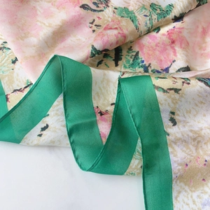 Detailed view of floral silk scarf featuring elegant rolled edges and soft ink painting style
