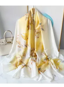 Detail of elegant floral chiffon scarf with yellow leaf prints on silky white background