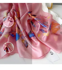 Detailed macro view showing the smooth texture and leaf pattern of a pink silk scarf