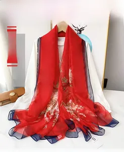 Detail of red floral chiffon scarf with peony pattern and blue contrasting border trim