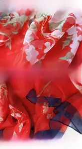 Detail view of red floral shawl showing breathable fabric and high-density stitched edges