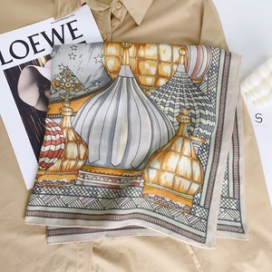 Close-up of luxury blue castle silk scarf with onion dome print on a khaki shirt