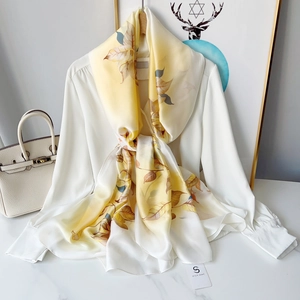 Elegant yellow floral chiffon scarf with autumn leaf patterns on white blouse