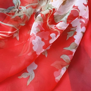 Close-up of lightweight red chiffon scarf with vibrant floral print and sheer texture