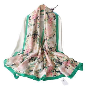 Elegant off-white silk-like shawl featuring pink floral patterns and a green satin border