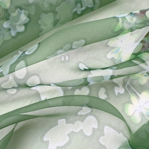 Close-up of lightweight green floral chiffon scarf with translucent draped texture