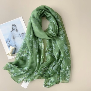 Detail of green floral gauze shawl showing its breathable thin texture and elegant pattern