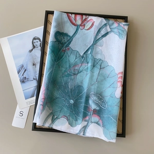 Detailed shot of large sheer floral scarf with green lotus leaves on a black frame