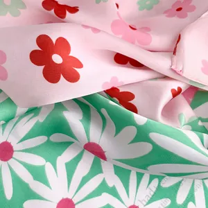 Detail of soft satin fabric showing floral patterns in pink and mint green finishes