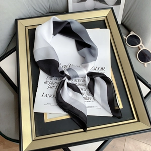 Close-up of geometric striped faux silk square scarf with elegant knotted styling