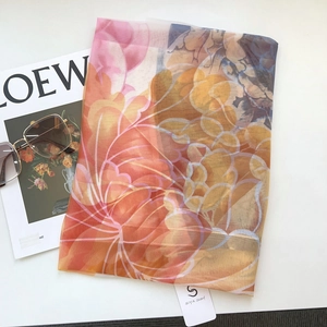 Detailed macro view of sheer floral chiffon scarf with elegant magazine and sunglasses