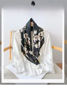 Close-up of 100% polyester scarf with white magnolia floral print on black fabric