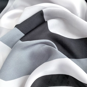 Macro shot of faux silk scarf featuring modern black and white geometric pattern texture