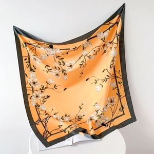 Detailed close-up of silk-like square scarf featuring elegant white magnolia flowers