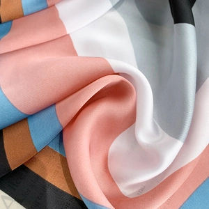Detailed close-up of colorful striped faux silk fabric with elegant satin luster and drape