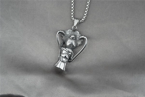 Détail du pendentif poupée opéra chinois argentée avec ruban en cœur sur chaîne perlée