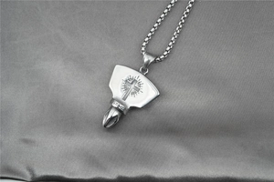 Détail macro du collier en acier titane argenté avec pendentif bouclier croix