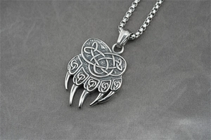 Gros plan du pendentif griffe d'ours vintage avec motifs celtiques et chaîne à mailles