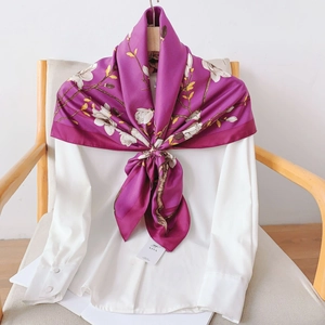 Detail of elegant purple silk scarf featuring white magnolia floral prints on a white shirt