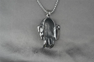 Detailed close-up of a silver stainless steel elephant skull pendant with a box chain