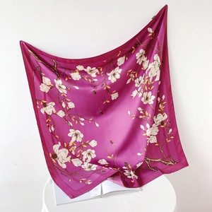 Detail of elegant magenta silk-like square scarf featuring realistic white magnolia prints