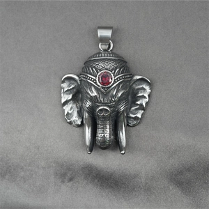 Vintage stainless steel Ganesha pendant with red zircon stone on dark grey velvet