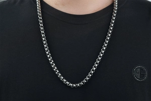 Nahaufnahme einer silbernen Edelstahl-Boxkette für Herren am Hals eines Models