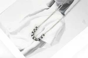 Detail of minimalist stainless steel Cuban link necklace with industrial splicing design