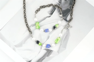 Détail d'un ensemble de bijoux bohèmes avec chaîne épaisse, perles en résine et perles