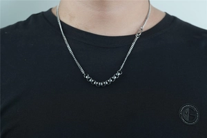 Close-up of minimalist silver stainless steel necklace with industrial style beads