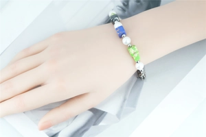Détail d'un bracelet de perles blanches et pierres minérales carrées bleues et vertes
