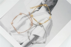 Detailed shot of three-tone daisy floral bracelets in gold, rose gold and silver finish