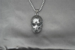 Macro d'un pendentif squelette gothique punk avec masque sur chaîne box vintage
