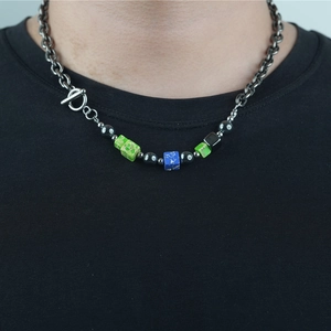 Collier de perles ethnique avec chaîne en argent et fermoir OT sur fond de t-shirt noir