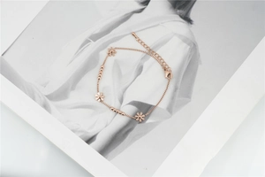 Detailed view of rose gold flower charm bracelet with lobster clasp and extension chain