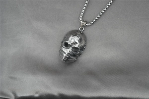 Détail du pendentif crâne gothique avec masque sur une chaîne en acier inoxydable