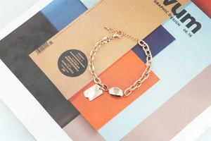 Detail of rose gold titanium steel link bracelet with Good Luck engraved square charm