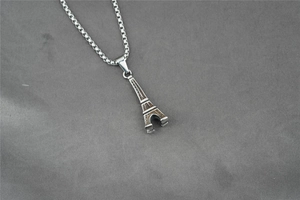 Macro view showing the 3D Eiffel Tower pendant with detailed box chain texture