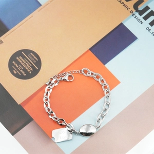 Elegant titanium steel chain bracelet with Good Luck charm on geometric background