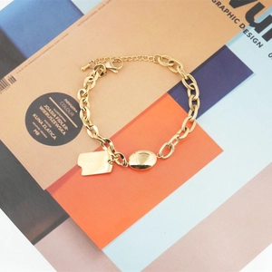 Elegant gold titanium steel bracelet with mixed chain links and Good Luck charm tag