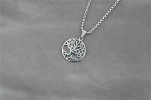 Detailed macro view of the Tree of Life cutout pendant and durable stainless steel box chain
