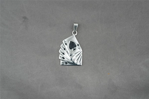 Macro shot of steel poker royal flush spade pendant on grey textured background