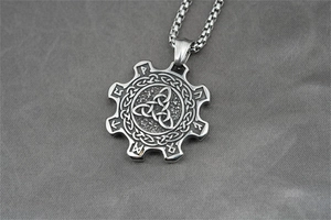 Close-up of vintage titanium steel gear pendant with Celtic knot and rune engravings