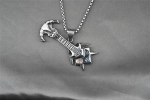 Macro shot of silver guitar-axe pendant with Chinese calligraphy engraving on metal